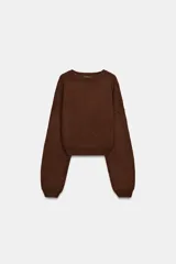 Jersey de punto liso con cuello redondo, manga larga y diseño de hombros caídos.