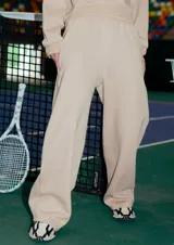 Pantalón tipo jogger de corte recto confeccionado en frisa color camel. Presenta cintura elastizada, bolsillos laterales y costuras verticales en el frente que le otorgan una estructura definida.