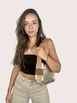 Cartera baguette dorada de cuero genuino, con asa reversible.