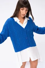 Cárdigan tejido azul eléctrico con cuello en V y cierre frontal con botones.