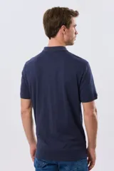 Remera polo de manga corta en color azul melange, con cuello camisero, cierre frontal de dos botones y pequeño bordado en el pecho.