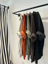 Camisa negra de pana con bordados florales a tono, corte oversize y ruedo curvo.