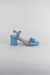 Sandalias de fiesta metalizadas color celeste, con taco cuadrado de 4 cm, tiras delanteras acolchadas y tira ajustable al tobillo con hebilla dorada.