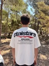 Remera oversize negra con diseño gráfico estampado en el pecho y en la espalda con inscripciones y líneas rojas.