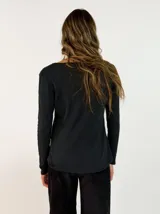 Remera de manga larga en color blanco, con cuello redondo y detalle de costura en el borde del escote. Confeccionada en tejido de algodón, presenta un corte recto y básico.