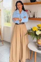 Pantalón de pierna ancha color beige, confeccionado en tencel. Presenta un diseño fluido y holgado con cintura elástica fruncida.