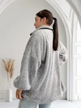 Camperón gris de tela tipo peluche con cierre frontal y bolsillos laterales.