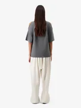 Remera gris de corte relajado, con diseño open shoulder y mangas cortas.