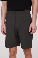 Bermuda de corte recto y diseño minimalista, confeccionada en tejido técnico de poliéster. Presenta cintura elástica con cierre de botón frontal, bolsillos laterales y un bolsillo pequeño adicional en el lateral izquierdo.