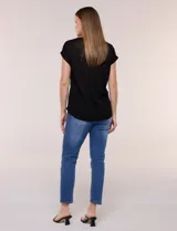 Remera de silueta relajada, de color negro, confeccionada en material de punto liviano. Presenta escote redondo clásico, mangas cortas de hombro caído con dobladillo fijo y ruedo redondeado.