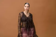 Saco de encaje semitransparente color marrón, con escote en V, volantes frontales, lazo ajustable y mangas largas con terminación acampanada.