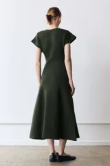 Vestido largo de punto en color verde oscuro jaspeado, con cuello redondo, manga corta y falda con corte evasé.