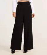 Pantalón pantalona de sastrería color negro, de cintura alta con diseño cruzado y hebillas laterales.