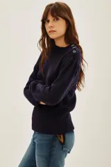Sweater de punto color azul marino, con cuello alto y detalle de botones decorativos en el hombro. Presenta mangas largas con puños acanalados y un ligero fruncido en la parte superior de la manga.