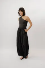 Pantalón negro de tiro alto, de corte amplio y fluido, con cintura elástica fruncida y bolsillos laterales.