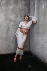 Pollera midi negra con detalle de cuero calado y flecos blancos en el ruedo.