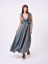 Vestido largo color gris con breteles finos y volados en el escote. Corte imperio y falda amplia.