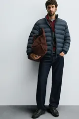 Cazadora acolchada de corte regular fit, confeccionada en tejido técnico repelente al agua. Presenta cuello subido, cierre frontal de cremallera, bolsillos laterales de vivo y puños con elástico.