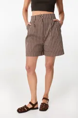 Short sastre de tiro alto, color marrón chocolate con rayas verticales blancas, pinzas frontales y dobladillo en el ruedo.