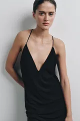 Vestido midi de color negro, con escote en pico y tirantes finos cruzados en la espalda.