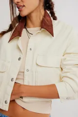 Campera corta de sarga de inspiración workwear, color amarillo con cuello en contraste marrón, bolsillos con solapa en el pecho y cierre frontal con botones.