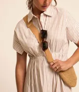 Vestido midi camisero de tricolina con estampado de rayas verticales finas en tonos beige y blanco. Tiene cuello solapa, mangas cortas con puños, abotonadura frontal y corte a la cintura.