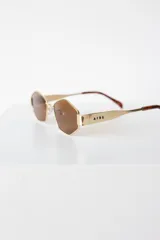 Lentes de sol con armazón y patillas metálicas doradas, diseño de forma geométrica hexagonal y cristales oscuros con protección UV400.