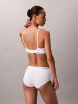 Bralette de triángulo Calvin Klein, confeccionado en una mezcla de algodón y modal. Presenta copas ligeramente forradas, tirantes ajustables y la icónica banda elástica con el logo de la marca. Diseño sin aros para mayor comodidad.