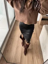 Vestido corto tipo strapless de efecto cuero negro, con detalle de puntilla en el ruedo.