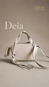 Cartera pequeña de cuero vacuno en color off-white, con diseño estructurado, doble asa corta y correa larga ajustable y removible. Incluye un detalle de flecos colgantes con argolla metálica y el logo de la marca grabado en el frente.