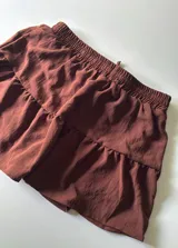 Minifalda marrón con volados y cintura elastizada. Incluye short interno.