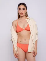 Top de bikini color naranja con textura, aro con forma de corazón en el centro, breteles finos regulables y copas desmontables.