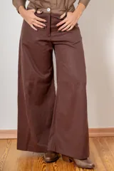 Pantalon de corte wide leg en color bordó, con cintura alta, cierre frontal con botón y bolsillos laterales.