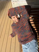 Sweater tejido a mano en lana color gris jaspeado, de calce holgado, con cuello a la base y puños ajustados.