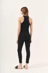 Pantalón negro de tiro medio, calce fit y largo al tobillo. Confeccionado en simil cuero con detalles en gamuza y cintura elástica.