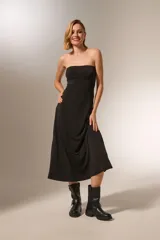 Vestido midi strapless de corte ajustado al cuerpo, confeccionado en tela de poliéster con cierre posterior.