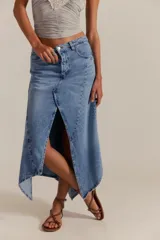 Falda larga de denim, de tiro medio y línea A, con abertura frontal, paneles con costuras y ruedo deshilachado en punta.