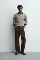 Pantalón de corte straight fit confeccionado en ante de color marrón, con diseño de cinco bolsillos y cierre frontal con cremallera y botón.