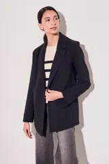 Blazer negro de corte clásico con solapas y mangas largas con puños con rayas verticales.