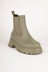 Botas Chelsea negras de caña baja, con elástico lateral y suela track.