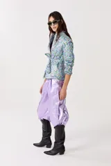 Chaqueta capitoneada con estampado floral y terminación metálica, cuello alto, cierre frontal escondido, cinturón para atar y bolsillos laterales.