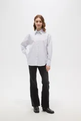 Camisa de algodón a rayas verticales, con cuello camisero, cierre frontal de botones y detalle de strass aplicado en la parte superior delantera.