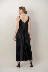 Vestido largo negro de satén plisado, con tirantes finos y escote en V.