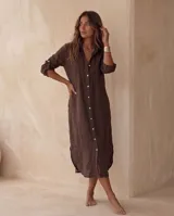 Vestido camisero midi blanco de lino, con cuello camisero, botonadura frontal completa con botones de nácar, mangas largas con tira para arremangar y abertura lateral en el bajo.
