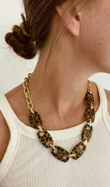 Collar de eslabones combinados con eslabones metálicos dorados y piezas rectangulares de resina con estampado animal print tipo carey.