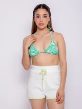 Top de bikini triangular con estampado de flores y ondas en tonos verde y blanco. Tirantes finos para atar en cuello y espalda. Cuenta con forro y copas desmontables.