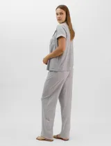 Set de pijama de tres piezas en color verde menta con estampado floral sutil, compuesto por una camisa de manga corta con botones, una musculosa básica y un pantalón largo de corte recto con cordón ajustable en la cintura.