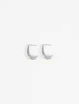 Aros tipo argolla con diseño de media luna en color plateado, con cierre de perno.