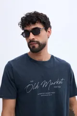 Remera de algodón con efecto lavado de estilo vintage, color marrón, con diseño de estampado tipográfico en el pecho.