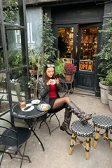 Botas de caña alta confeccionadas en cuero con efecto gastado. Presentan un diseño de estilo biker con múltiples hebillas laterales y apliques metálicos, incluyendo una argolla decorativa en el tobillo. Cuentan con un taco bajo cuadrado y suela de goma.